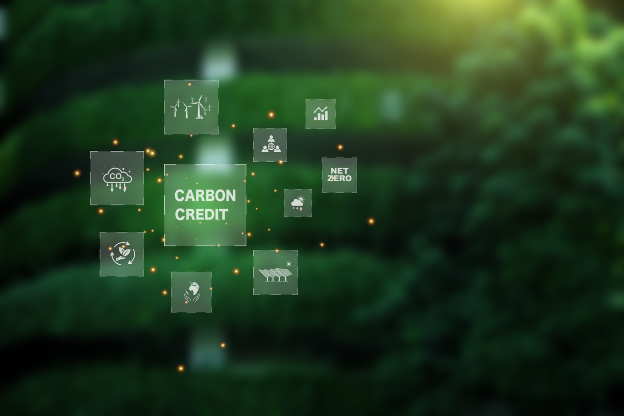 Carbon credit market concept. carbon credit icon on Green building covered with trees. Net zero in 2050. Green energy icon around it. Carbon Neutral in industry Net zero emission eco energy.